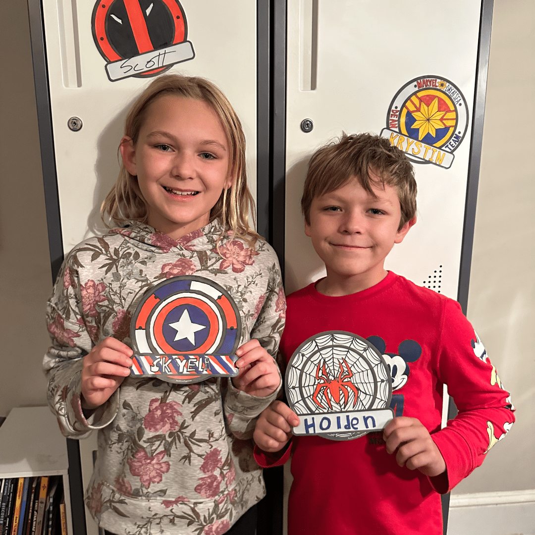 two elementary school age children, a boy and girl - holding cruise door decorations that they made themselves